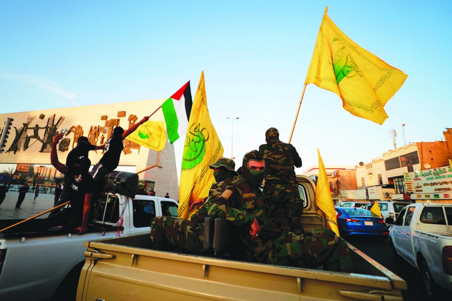 TOPSHOT - Members Iraq's Shiite Muslim al-Nujaba movement wave the Palestinian flag during a rally in Baghdad on October 8, 2023, to express their support of the "Operation Al-Aqsa Flood" which was launched by Hamas militants the previous day against Israel from the Gaza Strip. (Photo by Ahmad AL-RUBAYE / AFP)