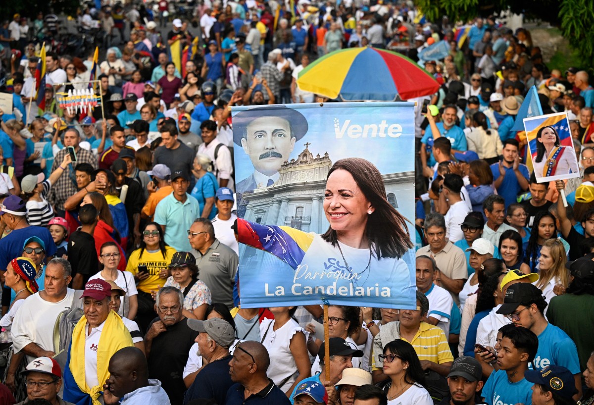 Demonstrators hold pictures of Venezuelan opposition leader and Nobel Peace Prize winner Maria Corina Machado during a rally to demand elections in Caracas on October 22, 2026. (Photo by Federico PARRA / AFP)
