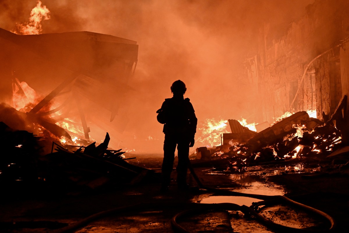 A Ukrainian firefighter extinguishes a blaze at the site of a Russian drone strike in Kharkiv on October 28, 2026, amid the Russian invasion of Ukraine. (Photo by SERGEY BOBOK / AFP)