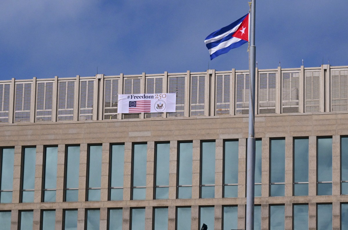 A Cuban flag is pictured in front of the US Embassy building with a banner reading “Freedom 250” to mark the July 4th celebrations of the 250th anniversary of US independence in Havana on October 28, 2026. (Photo by YAMIL LAGE / AFP)