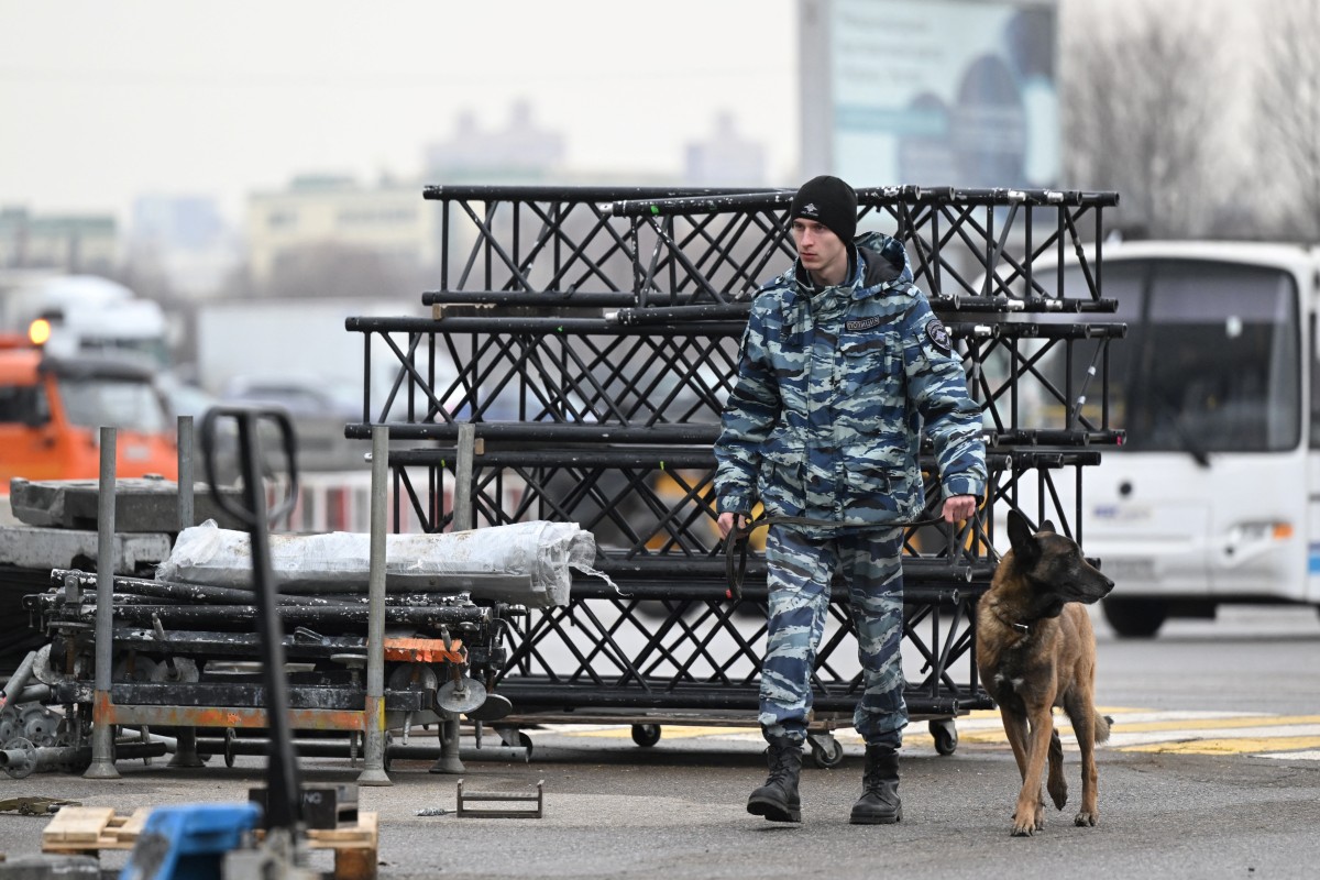 A Russian police officers with a dog secures the area outside the Crocus City Hall in Moscow's northern suburb of Krasnogorsk on March 29, 2024, a week after a deadly attack by gunmen on a Moscow concert hall killed at least 143 people and wounded dozens more. (Photo by NATALIA KOLESNIKOVA / AFP)