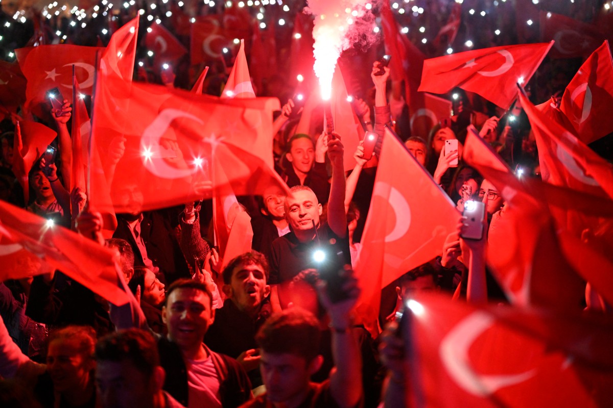 Opposition Republican People's Party (CHP) supporters celebrate outside the main municipality building following municipal elections across Turkey, in Istanbul on March 31, 2024.  (Photo by YASIN AKGUL / AFP)