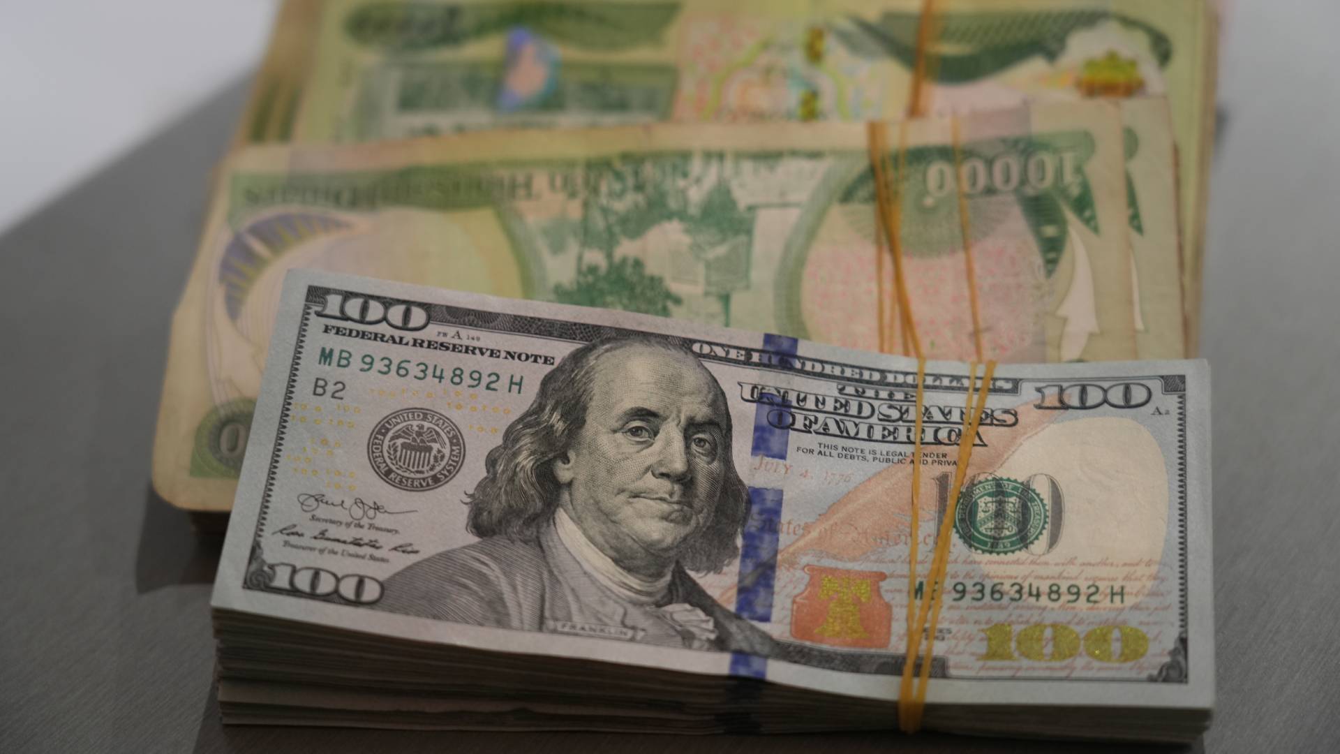 Stack of Iraqi Dinar and U.S. Dollar. Photo: Hama Sur / Channel8 