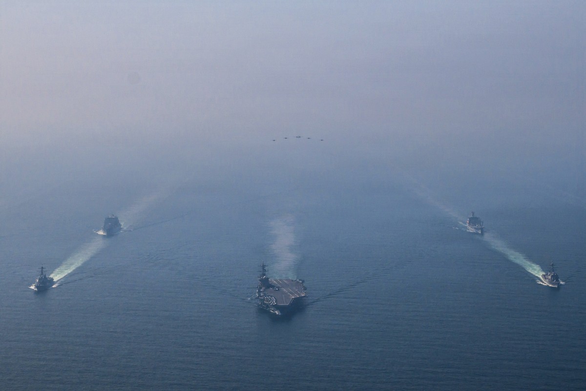 A U.S. Navy photo shows the aircraft carrier USS Abraham Lincoln sailing in formation with destroyers, support ships, and an oiler in the Arabian Sea on February 6, 2026.